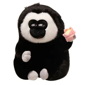 Simpatica scimmia saki dalla faccia bianca peluche che tiene un fiore di loto bambola