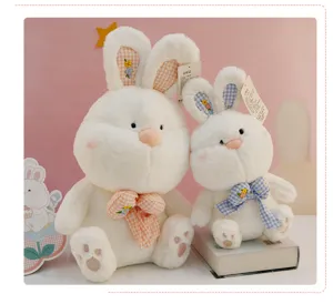 Gros plan détaillé de la jolie poupée lapin en peluche blanche avec nœud à carreaux.