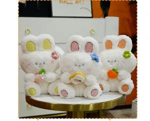 Vista dettagliata di simpatici coniglietti di peluche bianco seduti che reggono cibo.