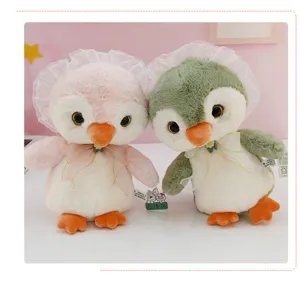 Close-up detail of cute penguin plush toy featuring soft lace bonnet and delicate bow ribbon.