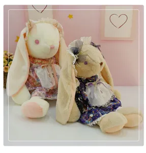 Detailed view of cute big-eared plush rabbit dolls wearing sweet floral dresses and lace.