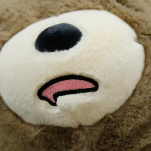 Bellissimo dettaglio cuscino peluche orsetto marrone, morbido tessuto con ricamo delicato.