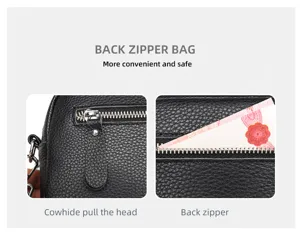 Detail view of black cowhide leather crossbody bag back zipper pocket and leather pull.