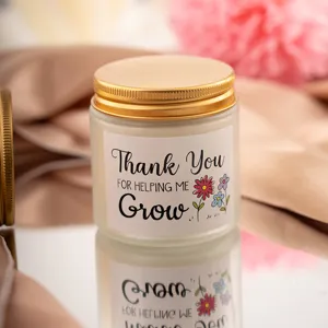 Detalle de vela aromática en tarro de vidrio esmerilado con etiqueta de agradecimiento