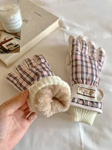 Gros plan détaillé de gants de ski à carreaux rose d'hiver montrant une doublure en peluche.