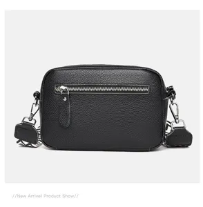 Close up of black genuine leather camera bag detail, metal zipper and patterned strap.