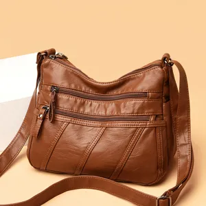 Stijlvolle bruine crossbodytas van zacht leer met meerdere vakken met ritssluiting voor dames.
