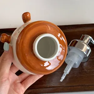 Ceramic soap dispenser bottle with cute cartoon design and pump for bathroom washbasin.