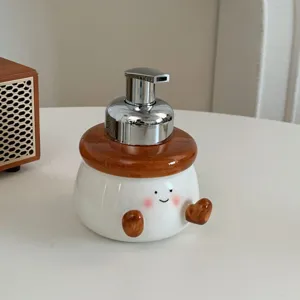 Close-up of cute chubby ceramic soap dispenser with smiling face and chrome pump head.
