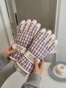 Vue détaillée de gants de ski à carreaux roses avec doublure polaire et lanière réglable.