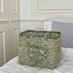 Quilted floral fabric storage basket with handles for home organization and bedroom decor.