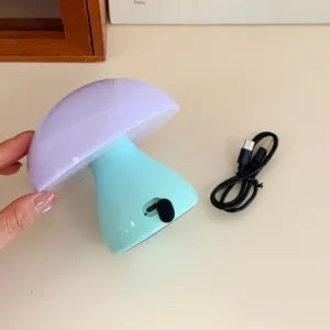 Creative mushroom night light with colorful silicone shade and USB charging cable for desk.