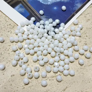 Détail en gros plan de perles facettées en acrylique blanc pour les bijoux artisanaux DIY.