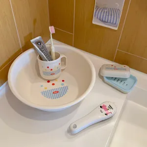 Detail view of student dorm wash basin set with cup, soap box, and brush on bathroom counter.