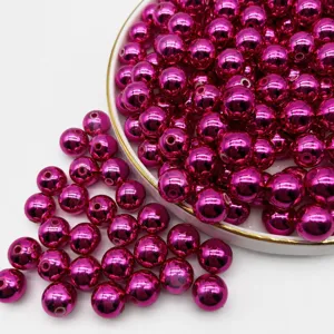 Abalorios redondos galvanizados en rosa fucsia con agujeros, ideales para bisutería DIY.