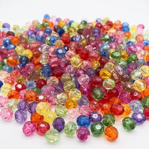 Vista detallada de cuentas facetadas de acrílico colorido, ideales para manualidades DIY.
