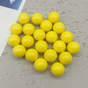 Primo piano dettagliato di perline tonde in acrilico giallo solido, ideali per creazioni fai da te.