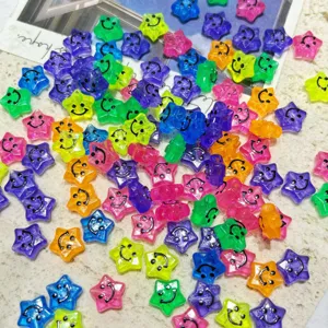 Gros plan de perles d'étoile en acrylique coloré avec visage souriant pour bijoux DIY.