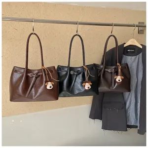 Detail view of stylish casual commute tote bag featuring cute pendant and belt detail.