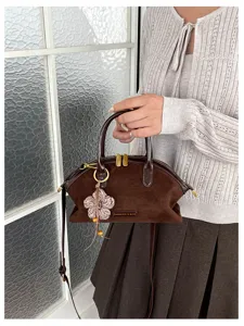 Sac à main vintage en daim marron avec charm fleur, élégant sac bandoulière chic.