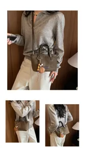 Detail view of the vintage suede bucket bag with wooden bead charm and stylish crossbody strap.