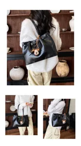 Detailed view of casual retro black PU leather tote bag with cute dog charm in nice setting