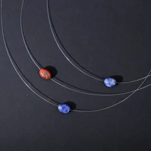 Detailed shot of transparent invisible fishing line necklace with natural gemstone pendant for women.