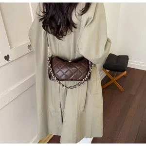 Detailaufnahme einer braunen gesteppten Kettentasche am Model in stilvollem Innenbereich.