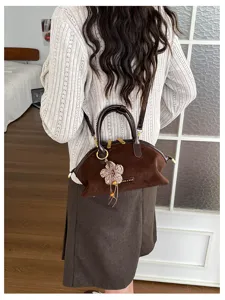 Vue détaillée du sac à main rétro en daim marron avec breloque fleur et détail en métal