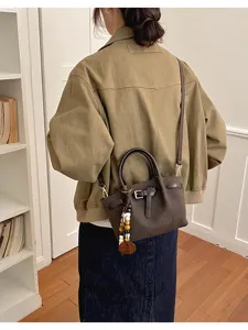 Vue détaillée du sac à bandoulière marron élégant, mettant en valeur sa belle boucle chic.