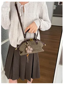 Vue détaillée du sac à main rétro en suédine, avec fermeture éclair et joli pendentif fleur.
