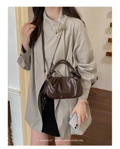 Vue détaillée d'un sac à bandoulière plissé marron élégant, au design et à la texture tendance.