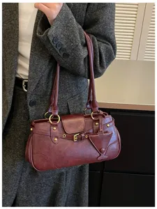 Detailed shot of a vintage maroon shoulder bag with unique martini charm and chic design.
