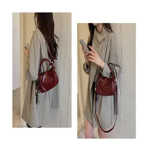 Gros plan détail du sac à épaule plissé rouge pour femmes avec poignée et bandoulière.
