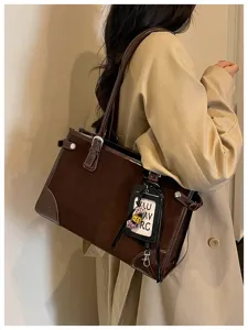 Vintage brown suede tote bag featuring contrast leather trim, stylish buckle, and spacious design.