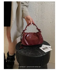 Sac à main froncé en cuir verni bordeaux élégant, vue de détail du design rétro chic et tendance.