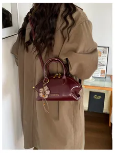Sac à main rétro en cuir verni bordeaux avec charm fleur, élégant sac bandoulière de travail.