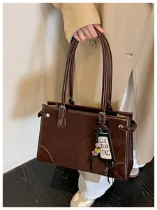 Brown retro tote bag detail, stylish women shoulder handbag with double handles and metal accent.