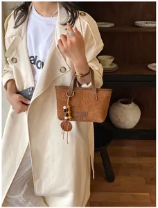 Retro suede bucket bag for women, chic crossbody shoulder bag with charm detail, elegant brown.