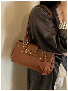 Vintage brown leather shoulder bag with buckle detail, chic underarm baguette style.