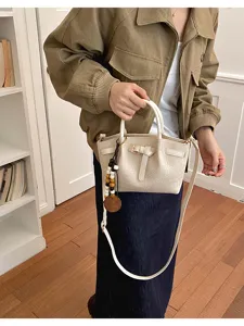 Sac à main élégant en cuir synthétique motif crocodile blanc avec bandoulière pratique.