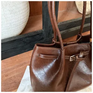 Brown faux leather tote shoulder bag close-up, retro style commuter bag with double straps.