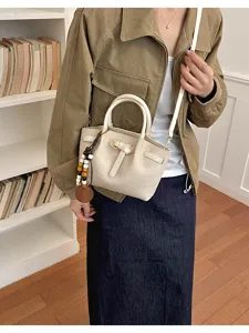 Élégant sac seau blanc avec motif crocodile et pendentif en perles pour les femmes.