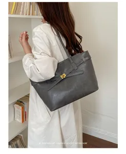 Detailed view of the vintage grey leather tote bag with elegant belt and turn-lock closure.