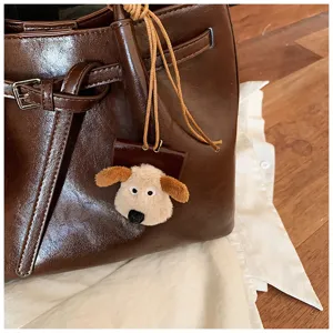 Brown PU leather tote bag featuring a cute plush puppy keychain, showing bag detail.
