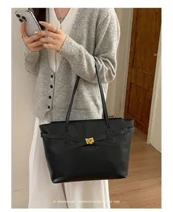 Detailed view of black minimalist shoulder tote bag featuring metal turn lock and classic straps.