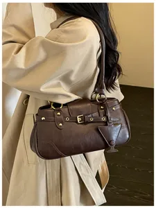Dark brown vintage leather shoulder bag detail, stylish baguette handbag worn by model.