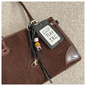 Vintage brown suede tote bag detail featuring dark brown leather trim and chic cardholder charm.