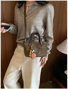 Retro suede shoulder bag detail view, stylish brown crossbody tote with wooden bead pendant.