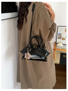 Sac à main en cuir verni noir en forme de coquillage avec pendentif fleur tricoté pour femmes.